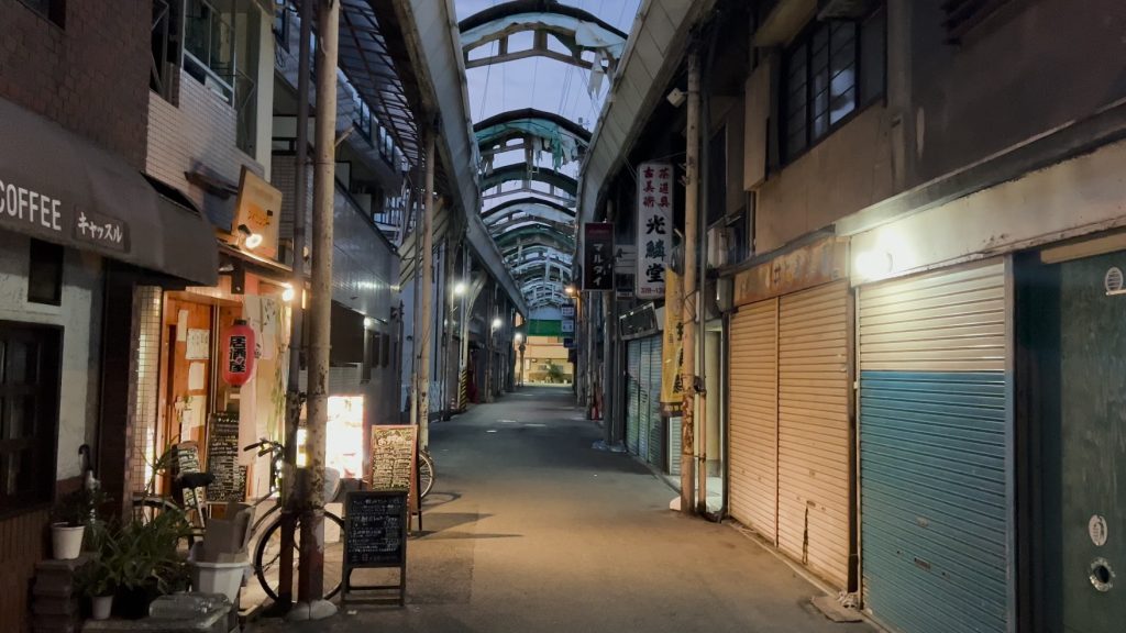 Dilapidated Inari Shotengai in Osaka with the lights from an izakaya visible.
